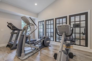 A home gym with a treadmill, elliptical trainer and a stationary bike.